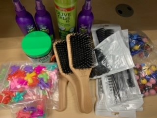 Hair Care kit containing brushes, detangle product, hair bands, picks, and combs