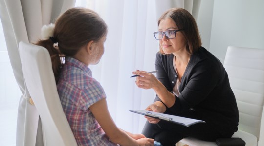 A social worker interviews a little girl.
